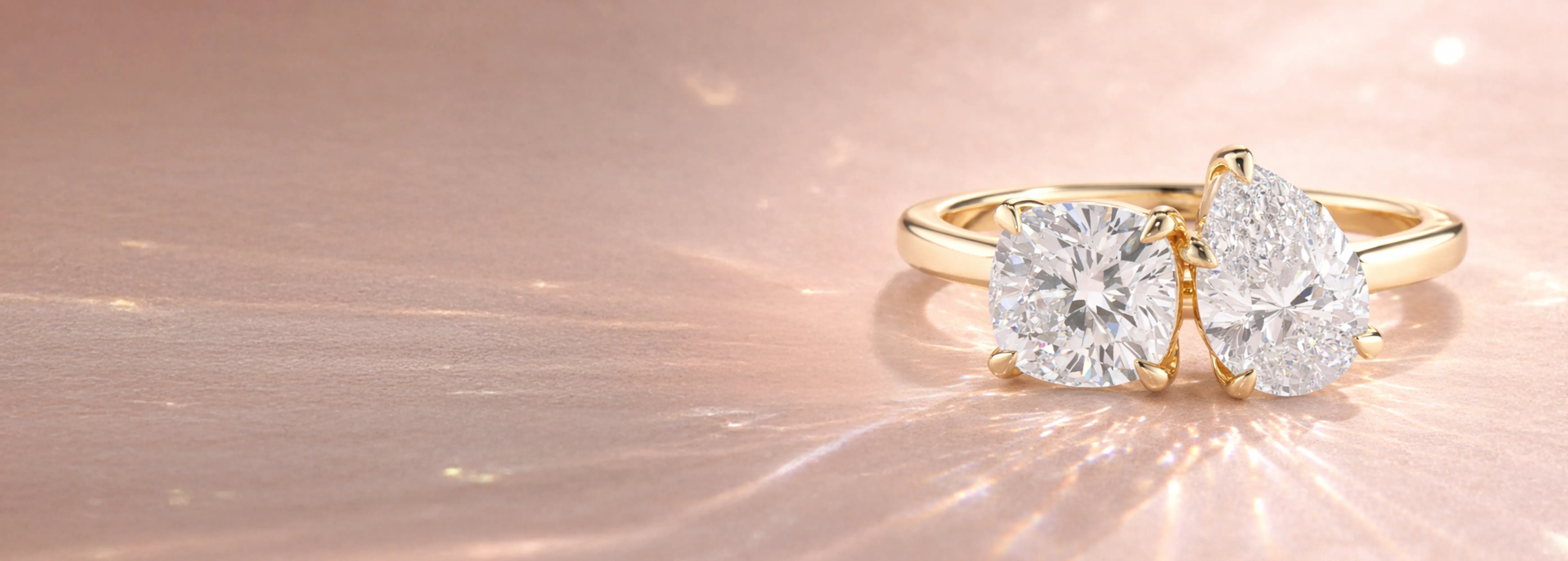 Two stone yellow gold diamond engagement ring with cushion cut and pear cut diamonds