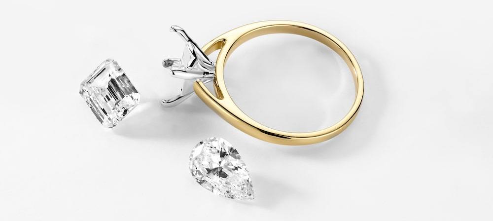 loose diamonds sitting next to an empty engagement ring setting