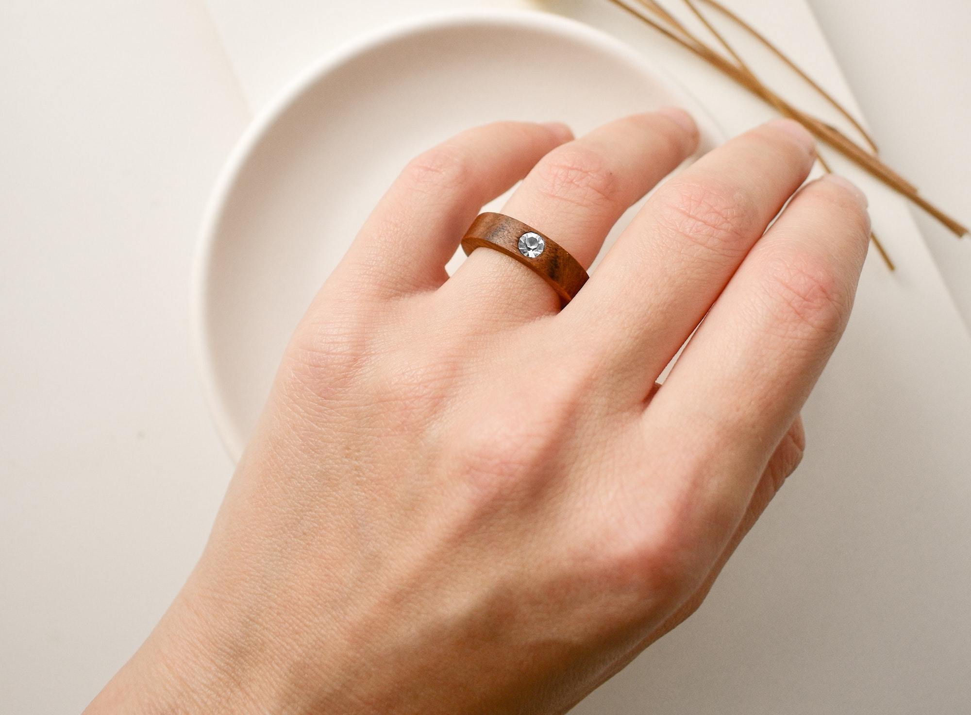 a wood wedding ring with a diamond at the center